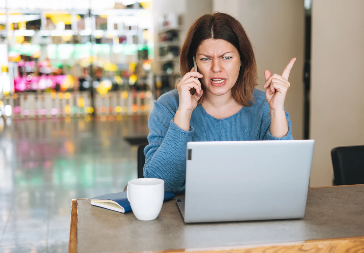 Encargada de atención al cliente respondiendo una reclamación por teléfono y laptop