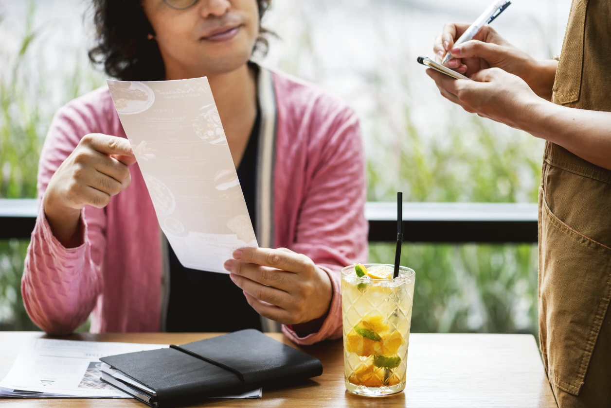 Cliente ordenando en un restaurante, experiencia positiva que fideliza la marca