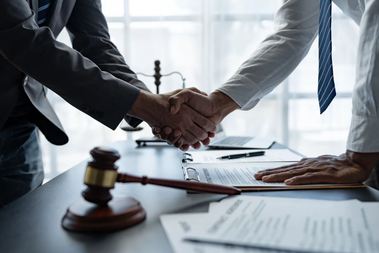 Abogados cerrando con un apretón de manos un acuerdo de mediación y arbitraje