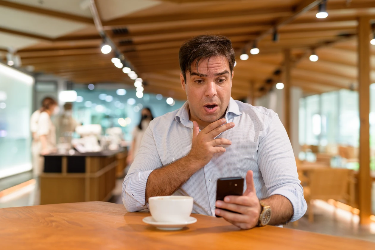 Empresario sorprendido en una cafetería al conocer las multas de INDECOPI